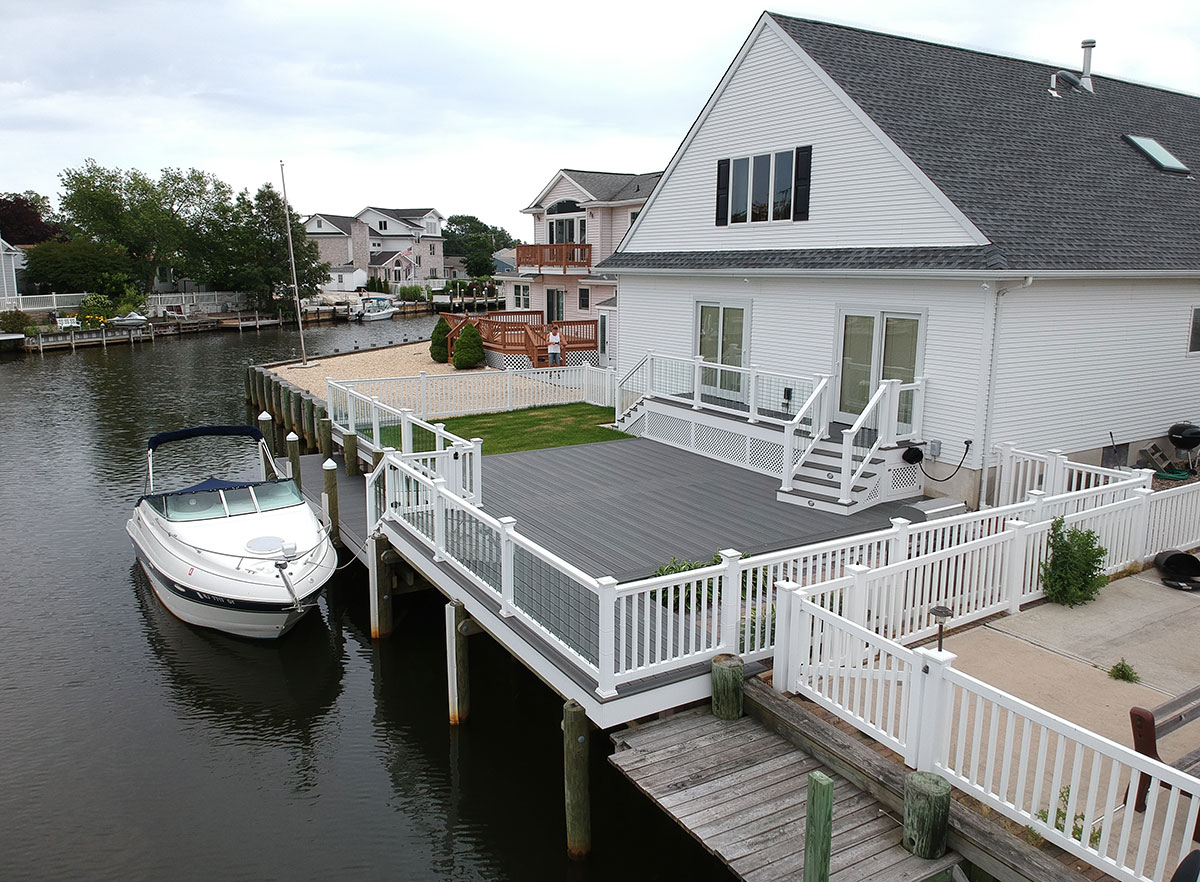 Optima Dekk fetured on a deck leading to a navigable waters with boat tied up.