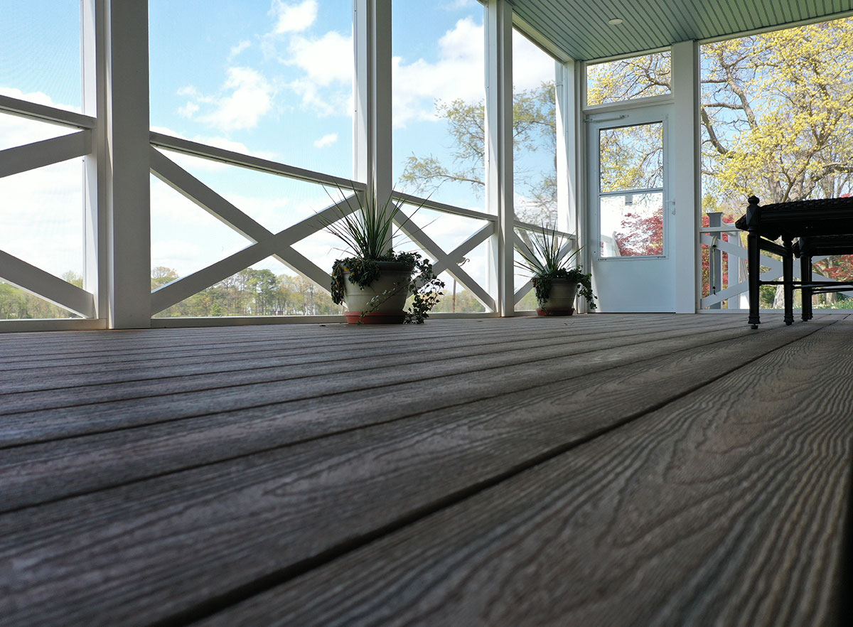 Optima Dekk featured in another screened in porch; composite decking in our armor cap finish .