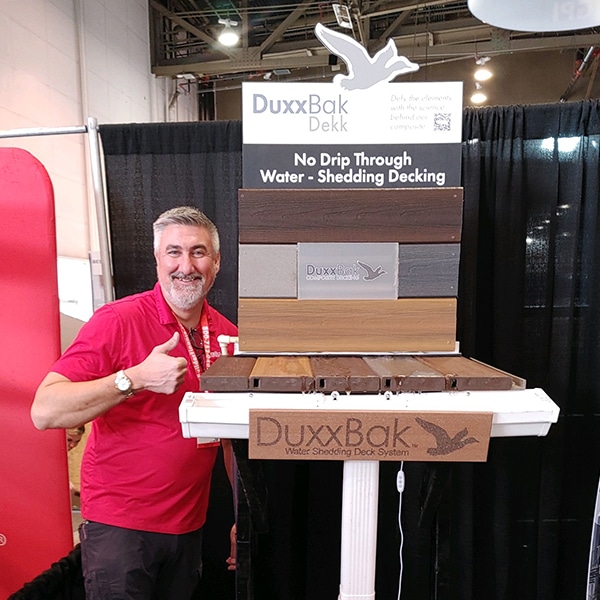 0226241310a-BrandonBeard-DuxxBakDekk-Display-at-IBS Image of the DuxxBak Dekk Display and DuxxBak Composite Decking President, Brandon Beard, at the IBS Show 2024 in Las Vegas.